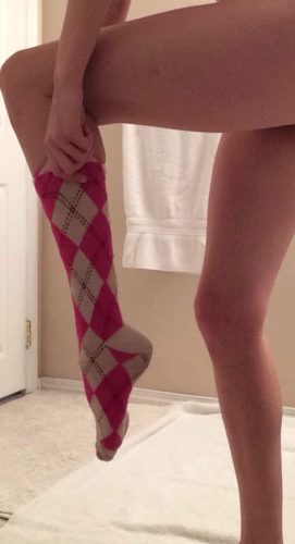 devojka navlači čarapu na nogu